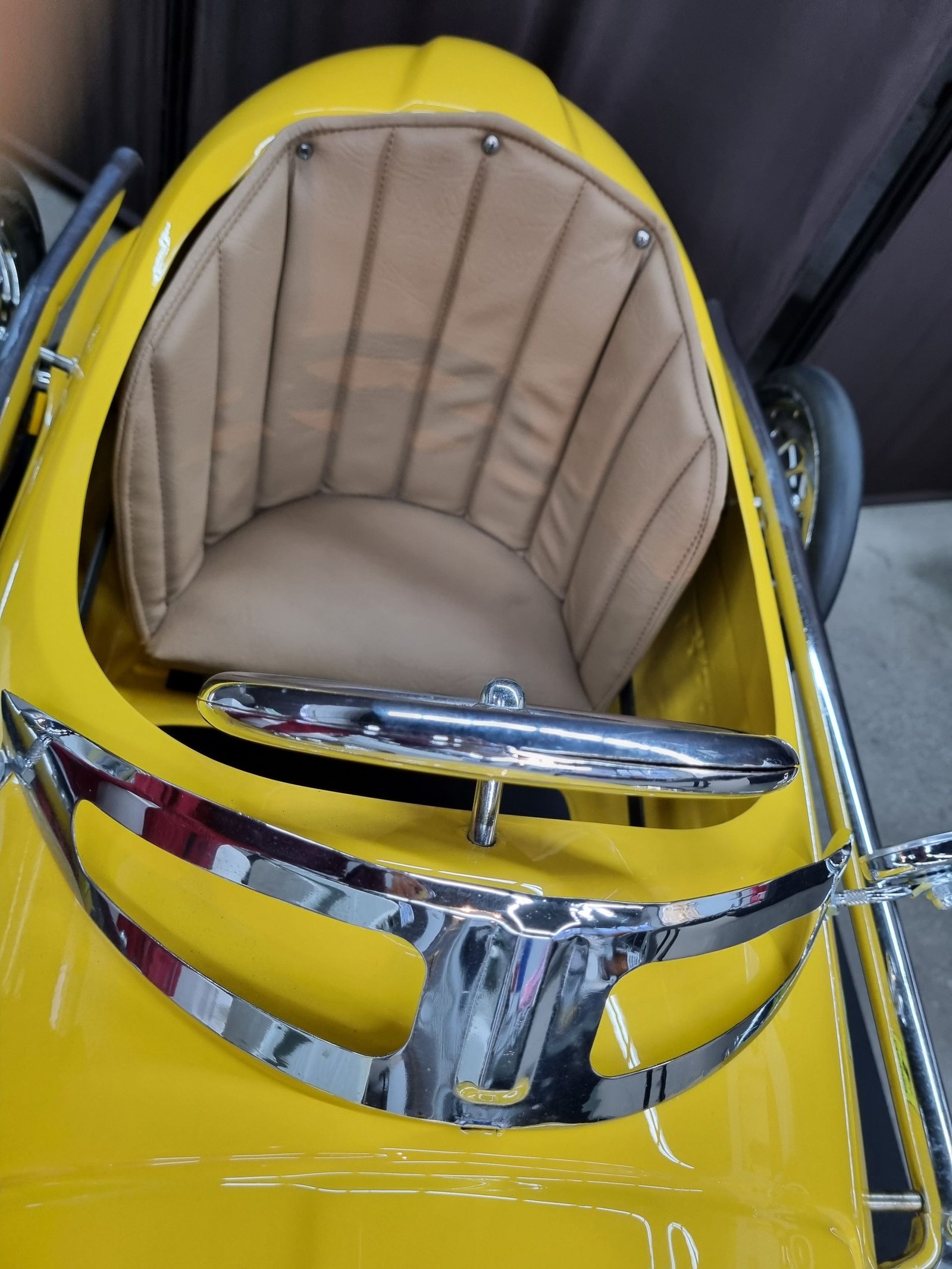 Ein gelbes Auto mit braunem Sitz und Chromverzierung